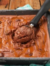 close up of chocolate caramel ice cream with cashew pieces and ice cream scoop