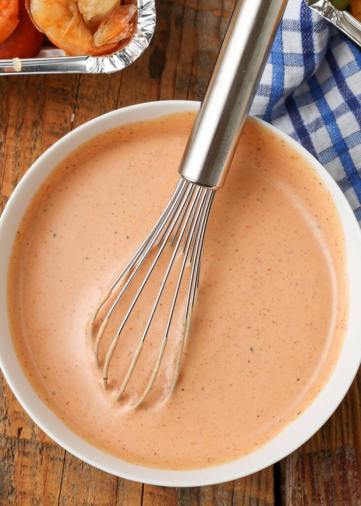 Overhead shot of bowl of Cajun Dipping Sauce with silver whisk
