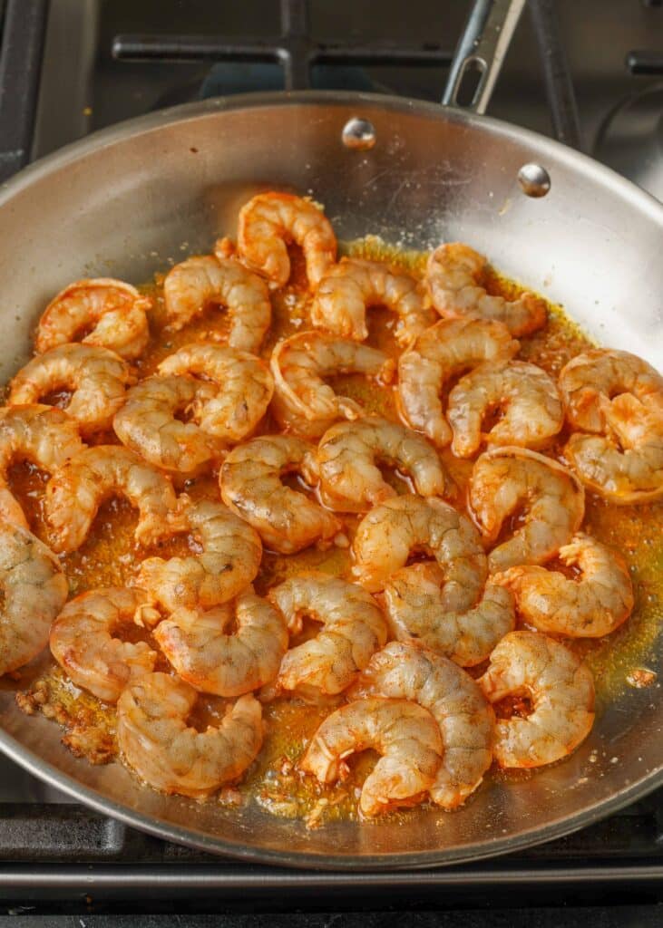 raw shrimp with sauce in skillet