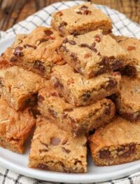 stacked blondies on pottery plate with plaid tea towel