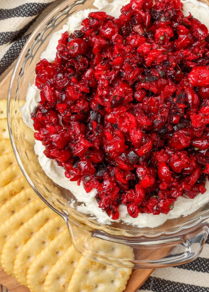 cranberry jalapeno mixture over cream cheese in dish with crackers