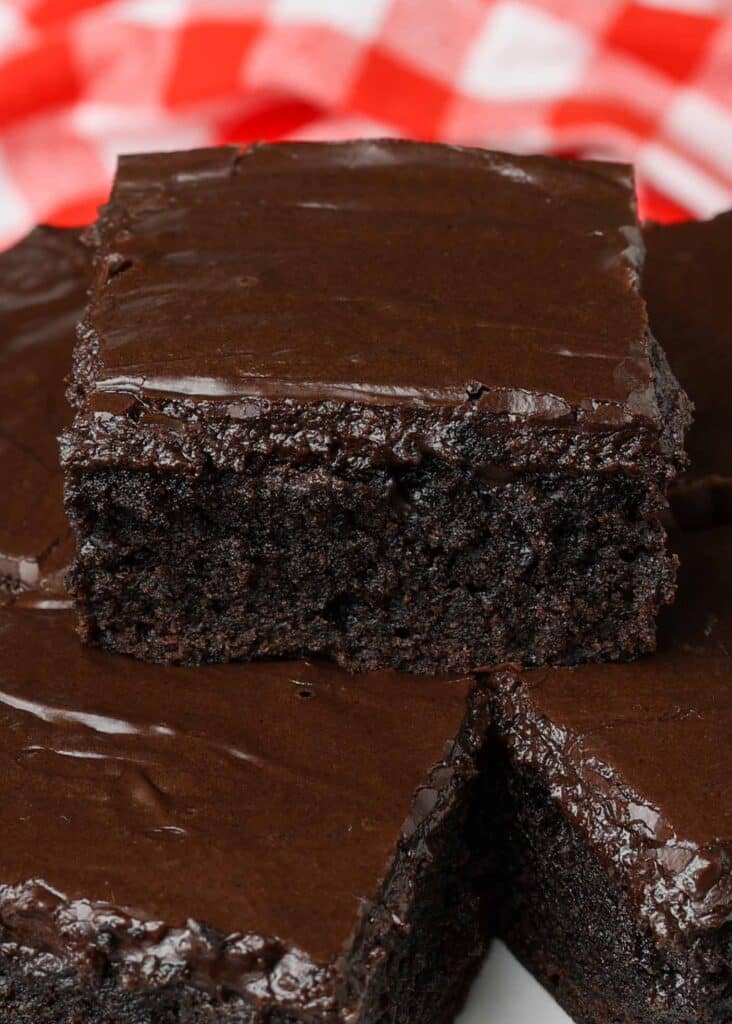 close up photos of brownie with thick chocolate frosting