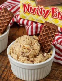 a vertically aligned photo of a scoop of nutty bars ice cream in a white ramekin with a box of nutty buddy bars visible in the background