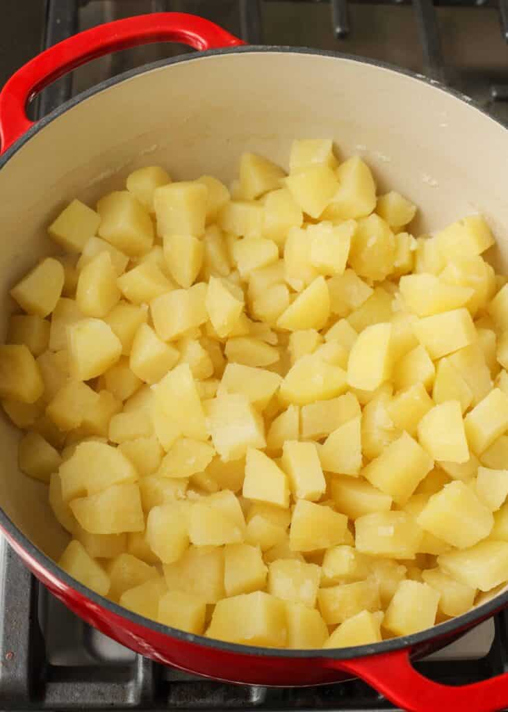 The potatoes have been boiled and drained, and are now returned to the pot.