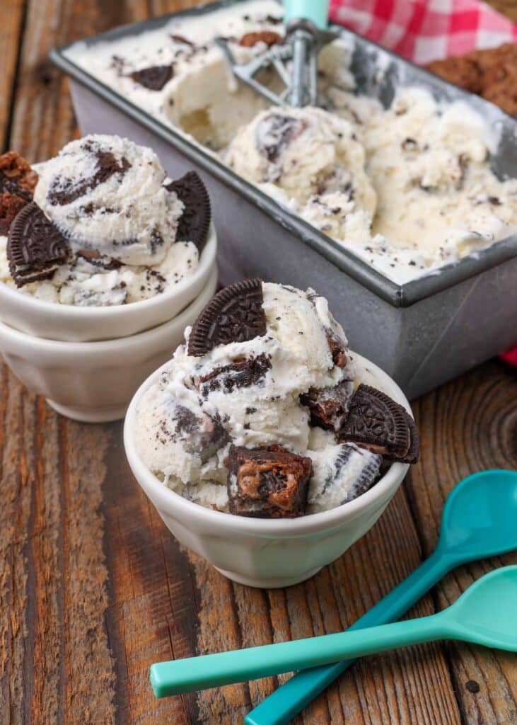 homemade ice cream with brownie chunks in pan with white bowls