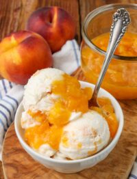 Peaches and cream ice cream, served in a wide white bowl with a silver spoon