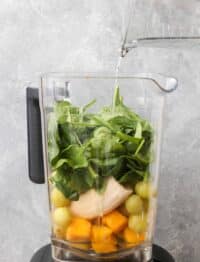 mango, grapes, banana, and spinach in blender for smoothie