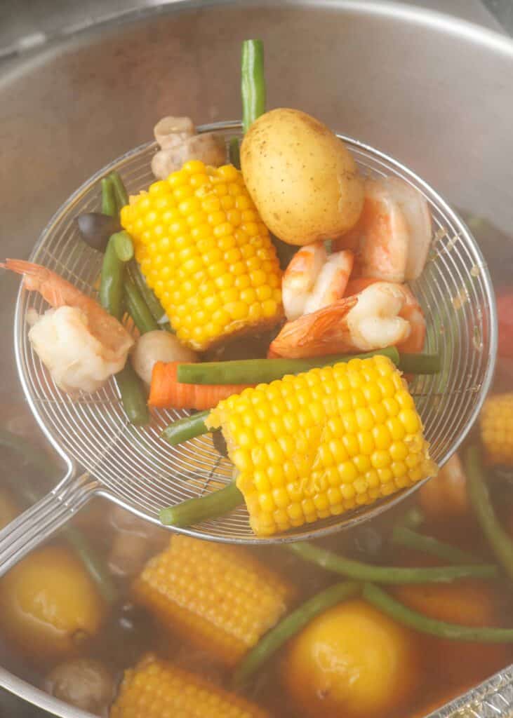 Shrimp and mixed vegetables strained in pot