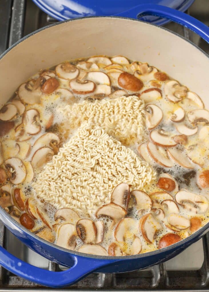 simmering stock in pot with mushrooms and ramen noodles