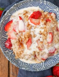 creamy oatmeal in blue bowl with strawberries